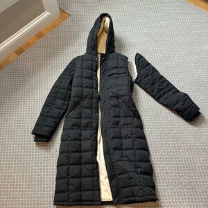 Women’s black long jacket converts to long vest. Sherpa lined upper.